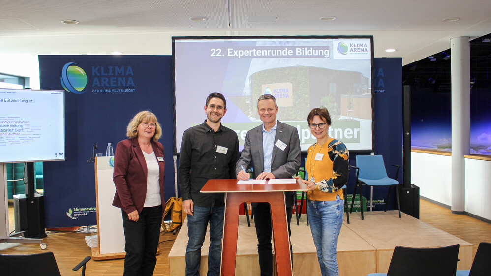 Vertreter der KLIMA ARENA und einer Partnerschule unterzeichnen Kooperationsvereinbarung.